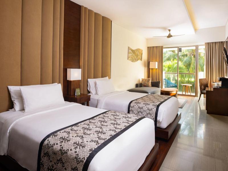 Pokój hotelowy z dwoma pojedynczymi łóżkami, dużym oknem i nowoczesnym umeblowaniem.