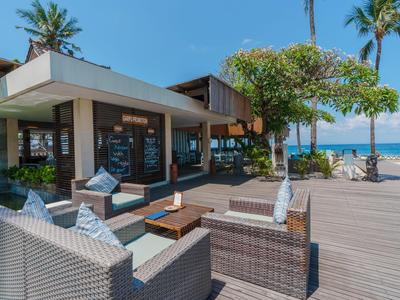 Modern outdoor hotel area with comfortable seating and sea view.