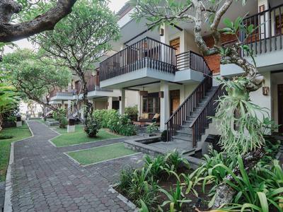 Hotel con senderos exteriores, jardín bien cuidado y balcones en entorno tropical