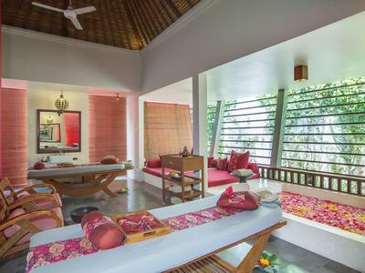 Sala de descanso de spa acogedora con tumbonas y ventana con vista al jardín.