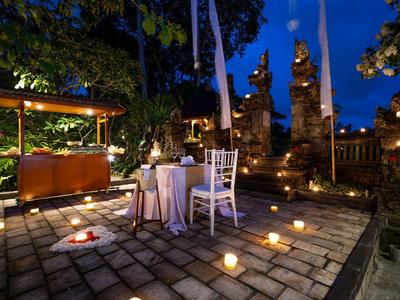 Romantický večer pod širým nebem se svíčkami a elegantním stolováním v zahradě.