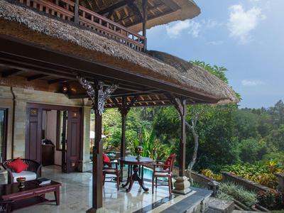 Terrasse mit Sitzbereich eines traditionellen Hauses mit Blick auf grünen Wald.