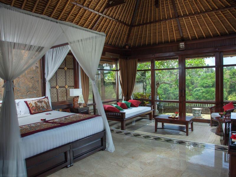 Luxusní pokoj s postelí s baldachýnem, velkými okny a výhledem na tropickou přírodu