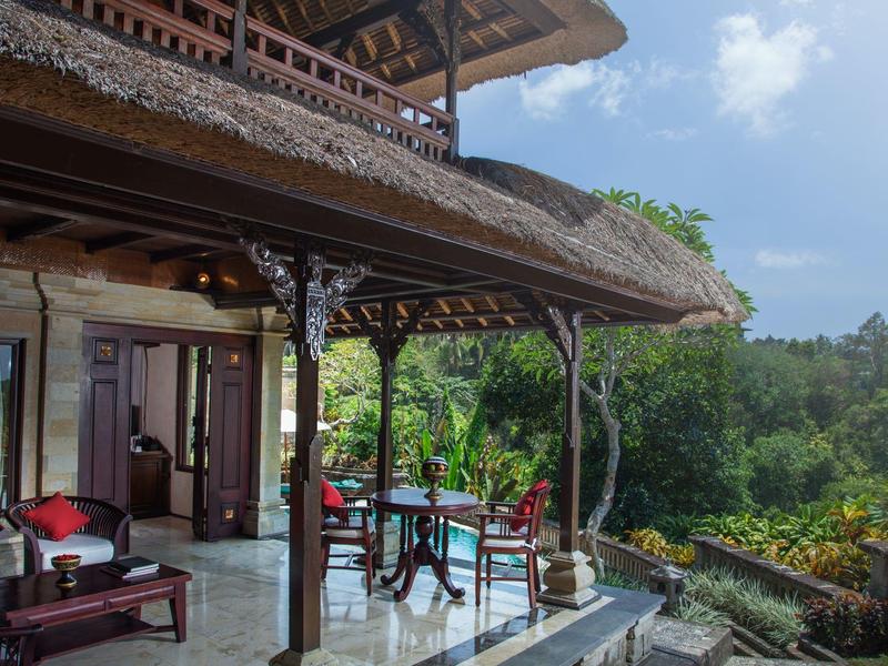 Zastřešená terasa s posezením s výhledem na bujnou džungli za denního světla.