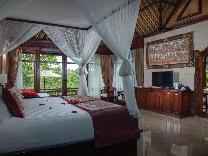 Luxusní hotelový pokoj s baldachýnovou postelí, televizí a výhledem na zeleň přes velká okna.