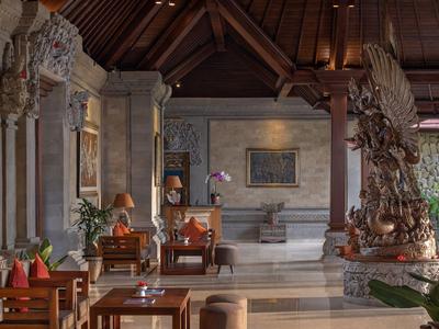 Elegancki hol hotelowy z rzeźbionymi drewnianymi rzeźbami i wygodnymi miejscami do siedzenia.