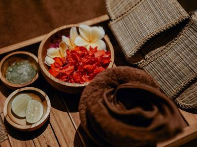 Handdoek, manden en kommen met citroen, kruiden en bloemen op een houten tafel.