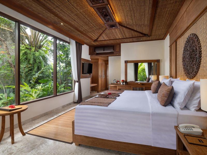 Moderne slaapkamer met groot raam en uitzicht op tropische tuin