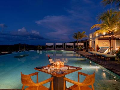 Soirée au bord de la piscine avec table dressée et ambiance détendue d'hôtel.