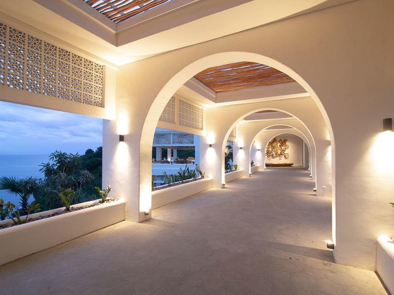 Großer heller Balkon mit Rundbögen und Blick aufs Meer bei Dämmerung.