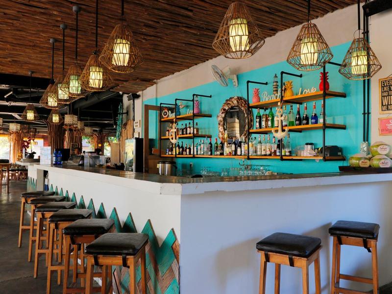 Bar accogliente con sgabelli di legno e luce calda in un interno elegante.