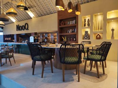 Nowoczesne wnętrze kawiarni z okrągłymi drewnianymi stolikami i czarnymi krzesłami