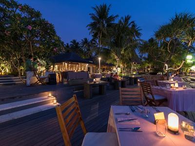 Romantyczna restauracja na zewnątrz z nakrytymi stołami i oświetleniem lampionów w nocy.