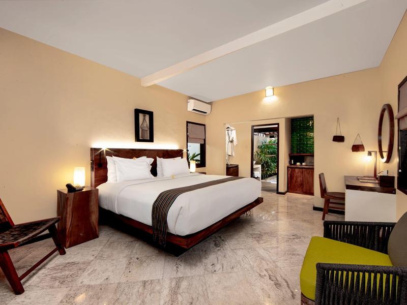 Nowoczesny pokój hotelowy z dużym łóżkiem podwójnym i widokiem na taras z ogrodem