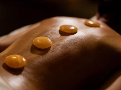Three warm stones placed on a person's back during a relaxing massage.