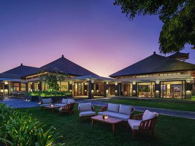 Luxury hotel with traditional roofs and comfortable outdoor seating at sunset.