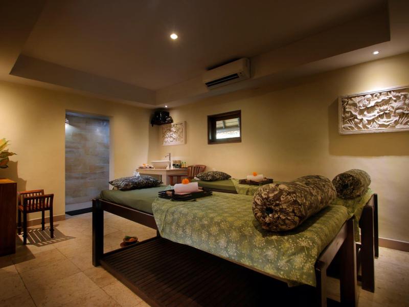 Salle de soin confortable avec tables de massage et éclairage chaleureux dans un spa.