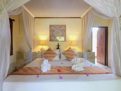 Gemütliches Doppelbett mit Baldachin und weißen Vorhängen in einem warm beleuchteten Zimmer.