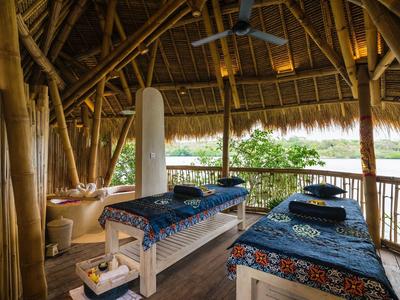 Accogliente sala massaggi con pareti di bambù e vista sulla natura