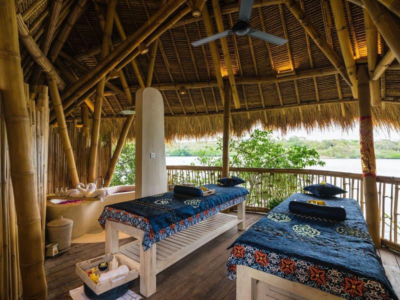 Accogliente sala massaggi con pareti di bambù e vista sulla natura