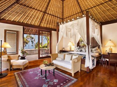 Gemütliches Zimmer mit Himmelbett, Holzdecke und Blick aufs Meer.