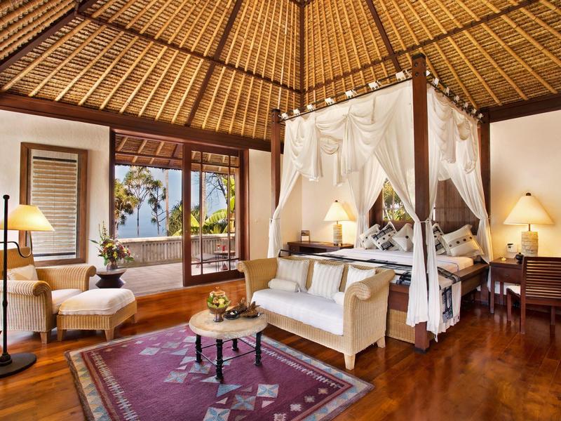 Gemütliches Zimmer mit Himmelbett, Holzdecke und Blick aufs Meer.