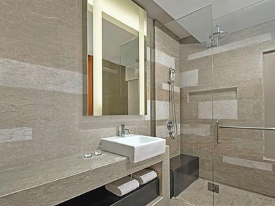 Bagno moderno con doccia in vetro, lavabo bianco e grande specchio a parete.