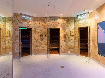 Moderner Spa-Raum mit großen Marmortüren und sanfter Beleuchtung.
