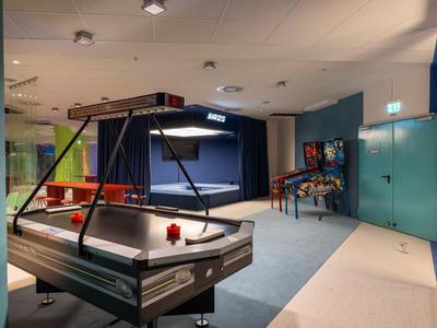 Innenraum einer Freizeiteinrichtung mit Airhockey- und Flipperautomat in Hotelnähe.