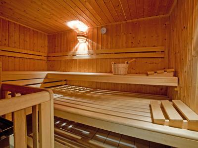 Gemütliche Sauna mit Holzbänken und gedämpfter Beleuchtung.