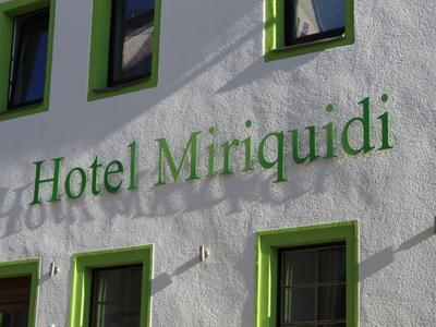 Außenwand eines Hotels mit grün gerahmten Fenstern und dem Schriftzug Hotel Miriquidi