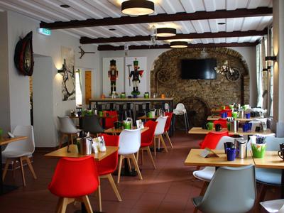 Gemütliches Restaurant mit bunten Stühlen und rustikalem Steinmauer-Design.