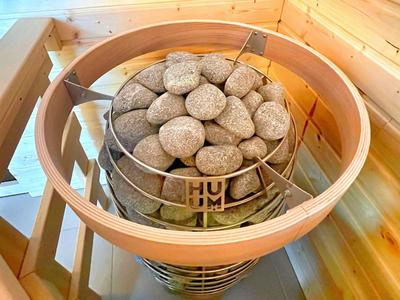 Saunaofen mit heißen Steinen in einer Holzkabine.