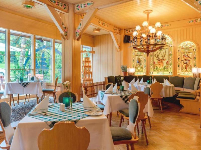 Cozy, bright restaurant with wooden furniture and large windows, stylishly decorated.