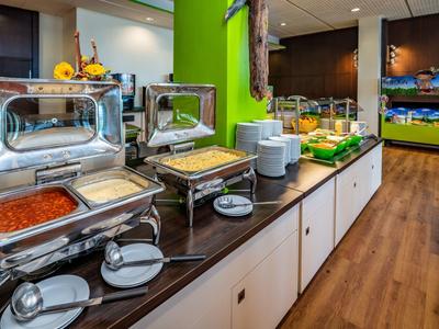 Buffet mit verschiedenen Speisen und warmen Gerichten in modern eingerichteter Kantine
