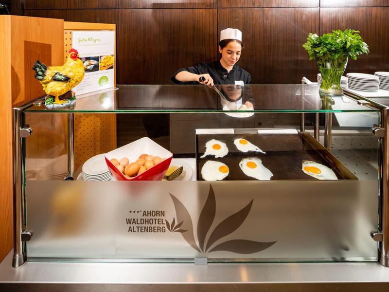 Hotelpersonal serviert Frühstück mit Eiern in einer modernen Buffetstation