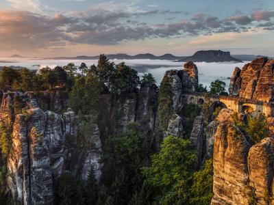 Felsformationen mit Bäumen bei Sonnenaufgang und Blick auf das Meer im Hintergrund.