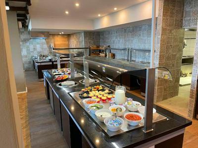 Buffet area with various foods and drinks in a hotel restaurant.