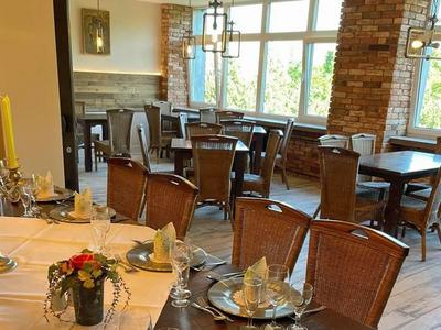 Elegant restaurant with set tables and large windows, bright and inviting.