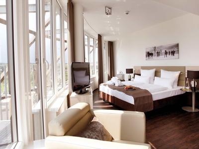 Modernes Hotelzimmer mit Doppelbett, Balkon und hellem, freundlichem Interieur.