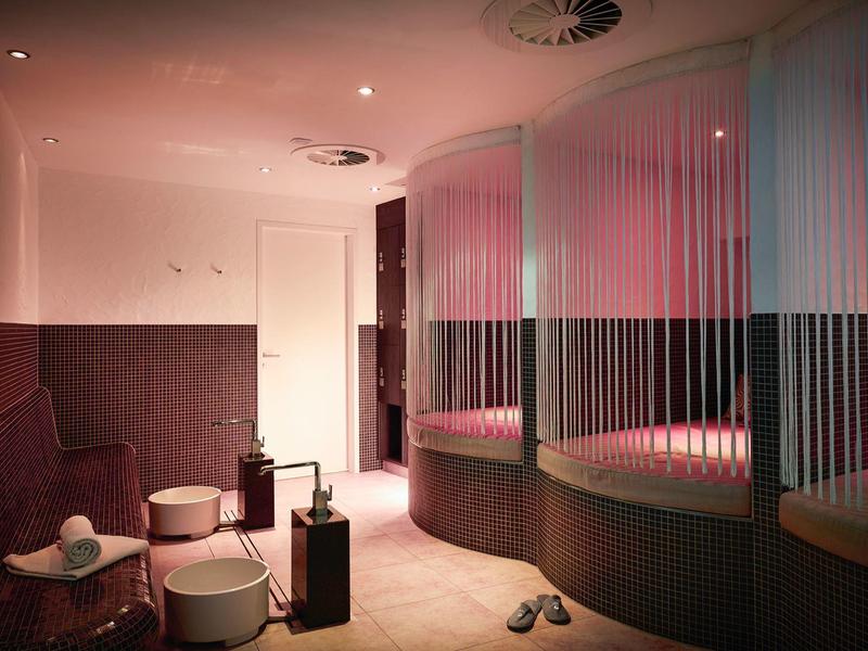 Moderner Ruheraum mit halbhohen Trennwänden, gemütlichen Sitzen, gedämmtem Licht und weichtem Teppichboden.