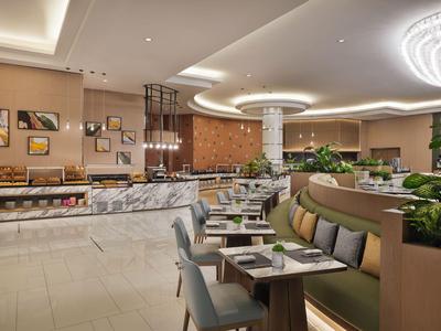 Modernes Hotelrestaurant mit eleganter Sitzanordnung, stilvollen Lampen und entspannter Atmosphäre.