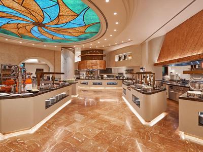 Elegante area buffet dell'hotel con design moderno e soffitto colorato in vetro.