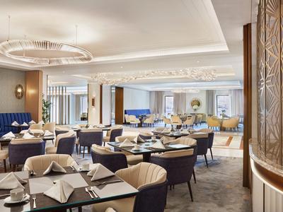 Ristorante elegante con tavoli moderni, sedie e illuminazione soffusa.