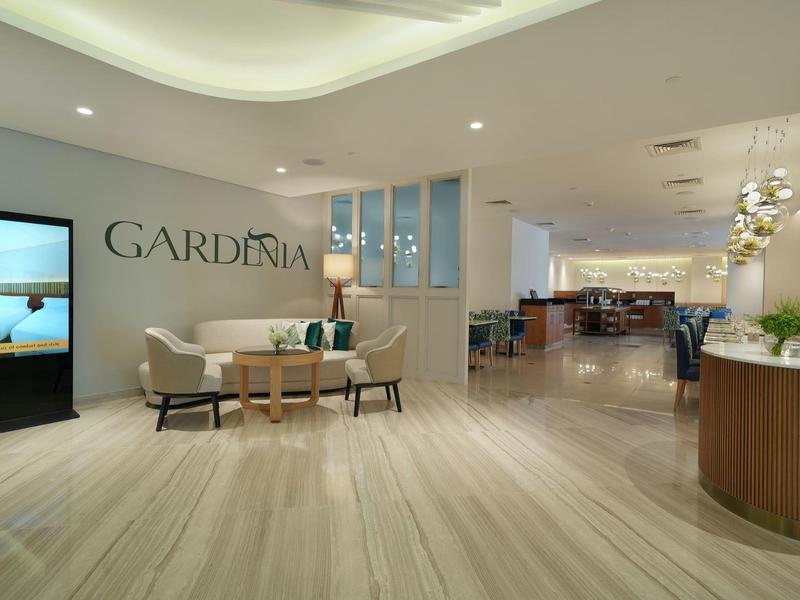 Moderner Empfangsbereich mit hellen Holzboden, Sofa, Beistelltisch und Wanddeko "GARDENIA".