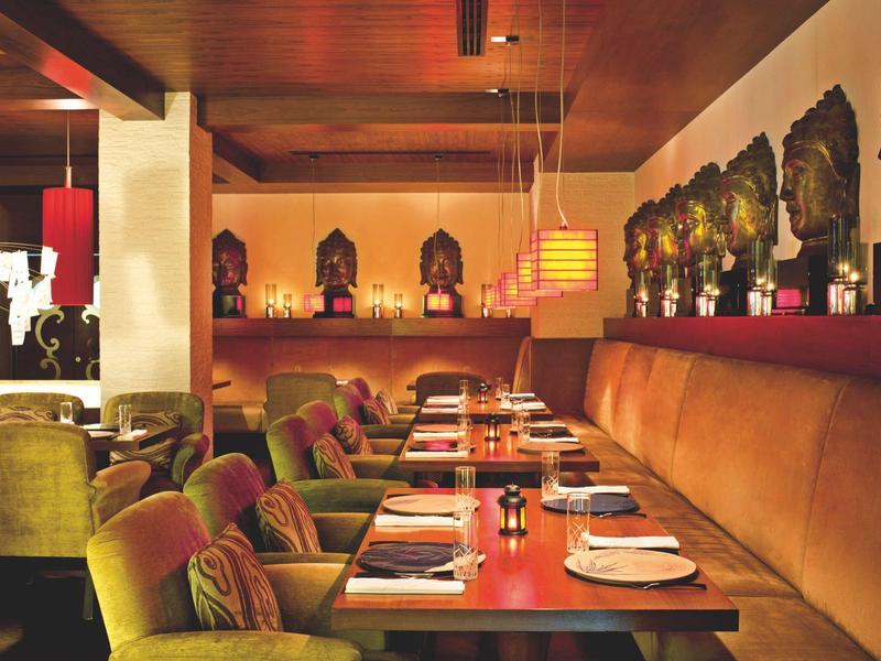 Gemütliches Restaurant mit Holztischen, braunen Polstersesseln und warmem Licht.