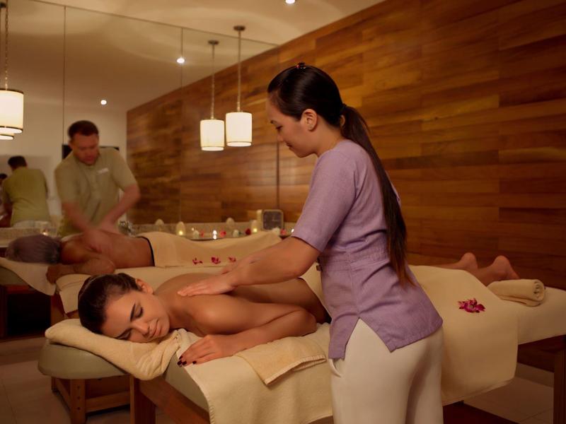 Ein heller Massageraum mit zwei Massageliegen, auf denen Kunden von Therapeuten behandelt werden.