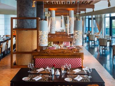 Elegantes Restaurant mit dekorativen Holzschnitzereien und stilvoll gedeckten Tischen.