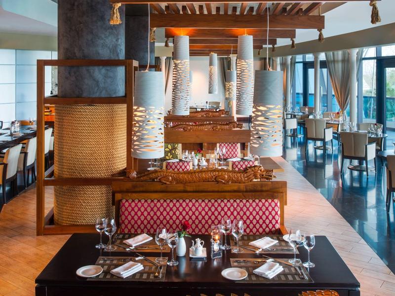 Elegantes Restaurant mit dekorativen Holzschnitzereien und stilvoll gedeckten Tischen.