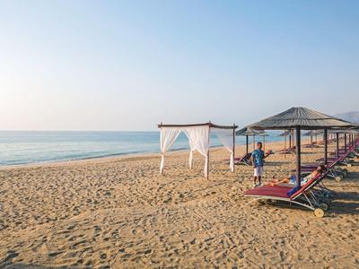 Leerer Strand mit Liegen und Sonnenschirmen bei klarem Wetter am Meer